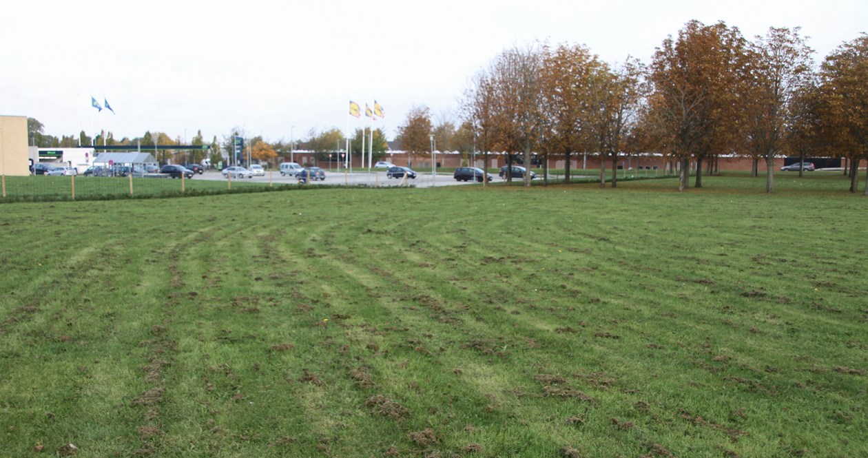 Cirkuspladsen i Jyllinge med p-plads og Jyllinge Centret i baggrunden